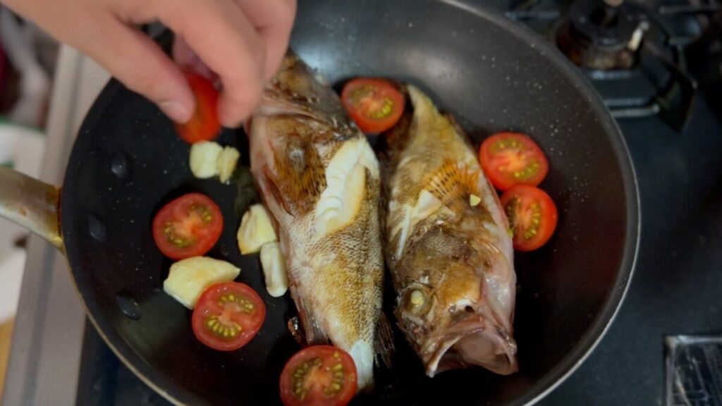  カサゴに半分ぐらい火が通ったらトマトを入れる